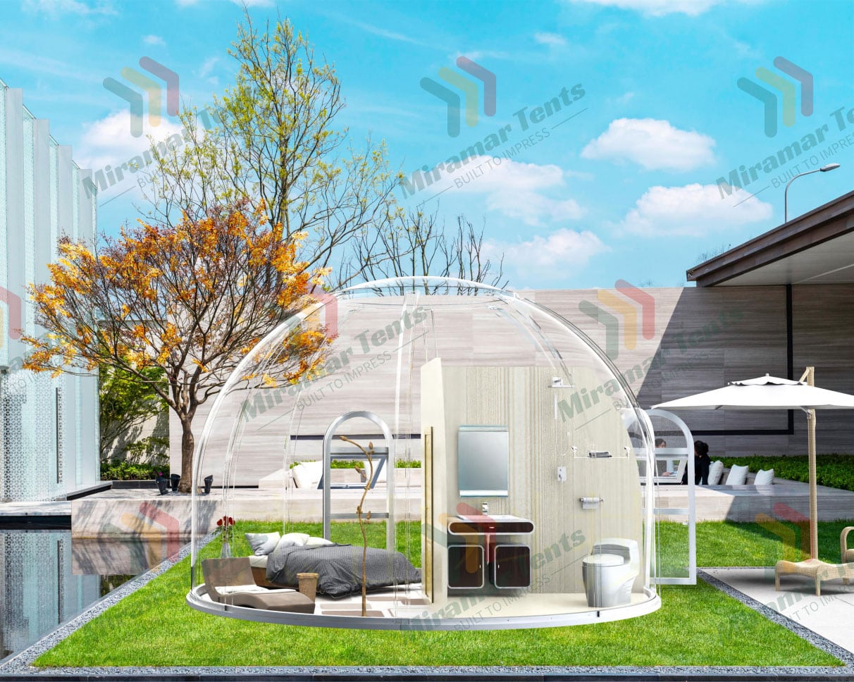 Transparent dome structure with modern interior setup beside a swimming pool in an outdoor setting.