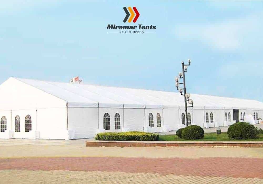 Large white All-Occasion Canopy Tent setup on a paved area under a clear sky, with the logo "miramar tents" displayed in the upper left corner.